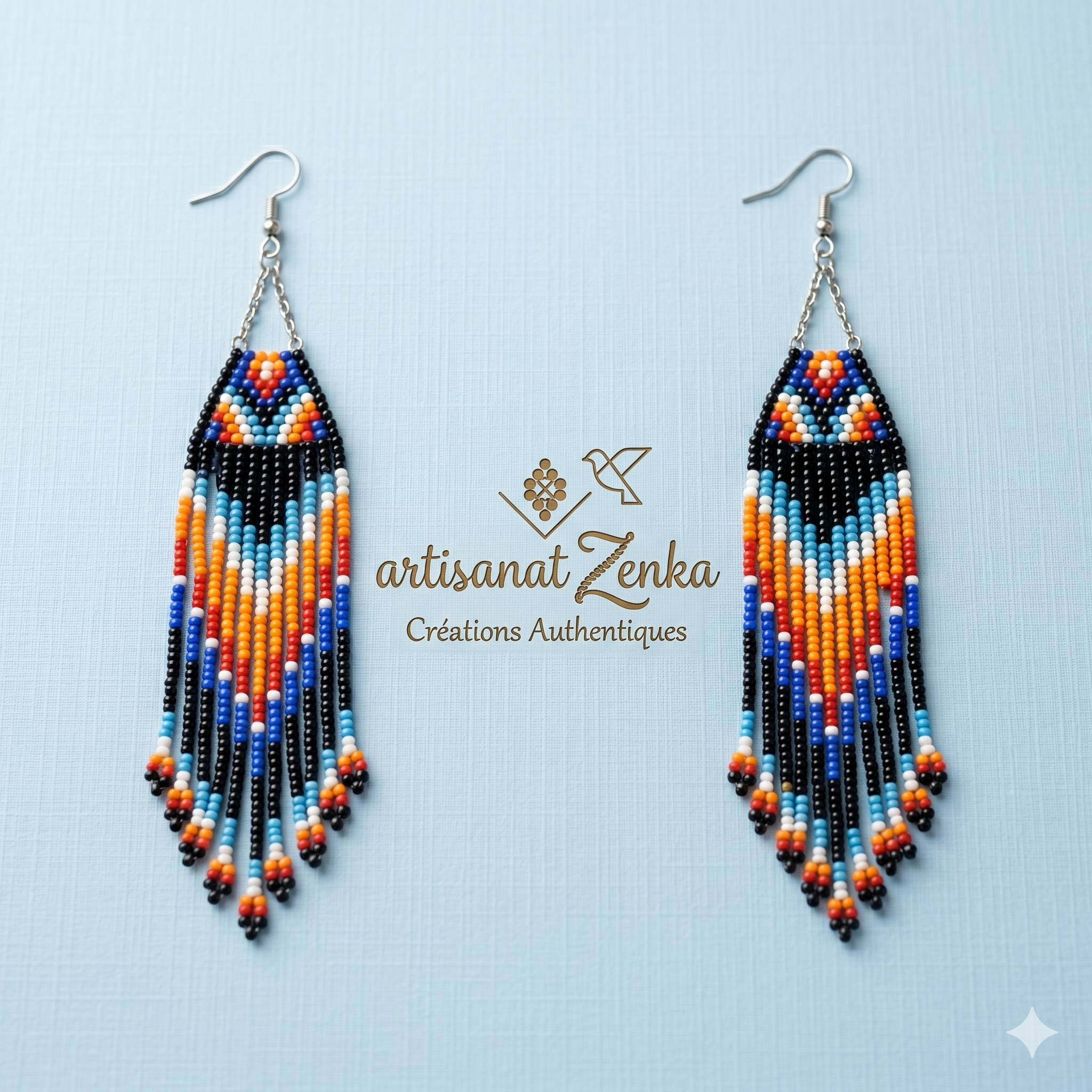 Paire de boucles d'oreilles artisanales en perles multicolores (bleu, orange, noir) sur fond bleu pâle avec logo Artisanat Zenka et signature Créations Authentiques.