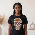 jeune femme portant un t-shirt noir unisexe avec un grand motif de crâne mexicain coloré et fleuri, style moderne et urbain.