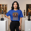 "T-shirt unisexe bleu roi avec illustration graphique Mama Africa représentant trois femmes africaines avec coiffes traditionnelles, porté par un mannequin dans une galerie d'art africain."