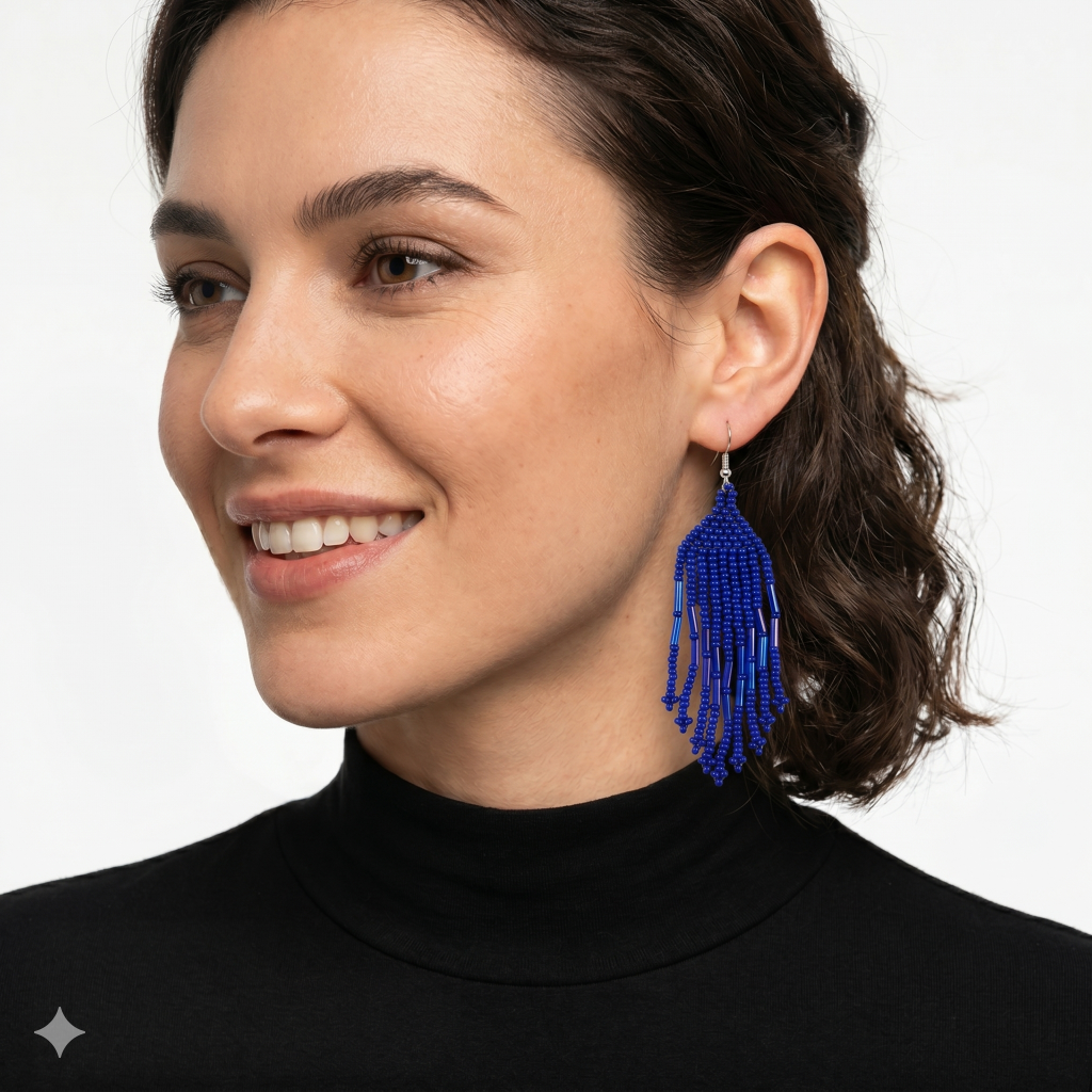 Femme souriante portant les boucles d'oreilles en perles bleues avec un col roulé noir, vue de profil.