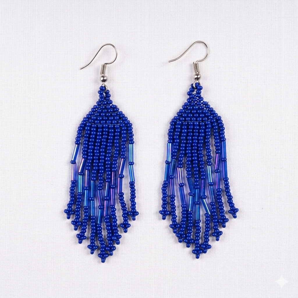 Paire de boucles d'oreilles pendantes en perles de rocaille bleu cobalt de style cascade sur fond blanc.