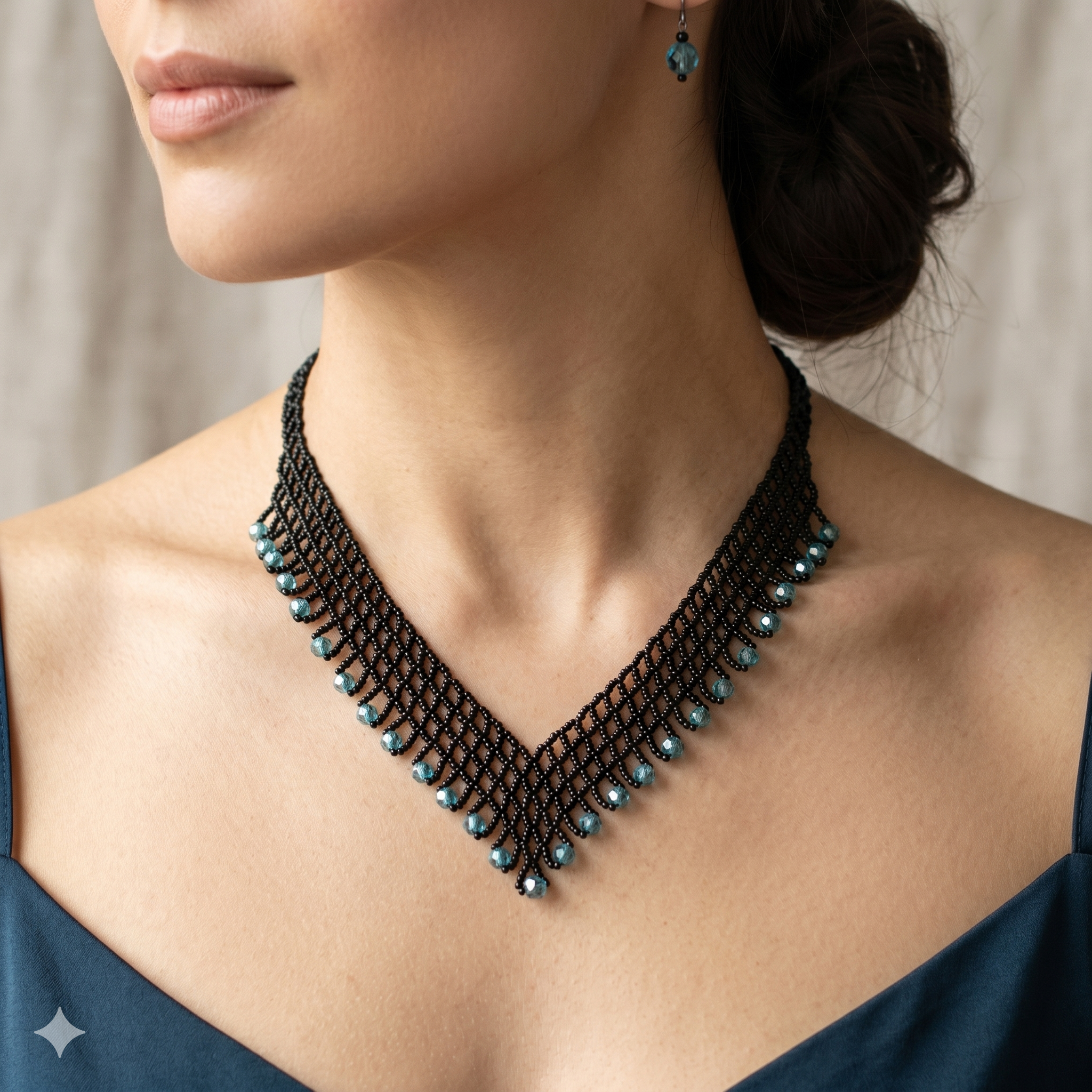 Femme élégante portant  un collier plastron en forme de V fait main avec un tissage de perles noires et des gouttes de cristaux bleu turquoise