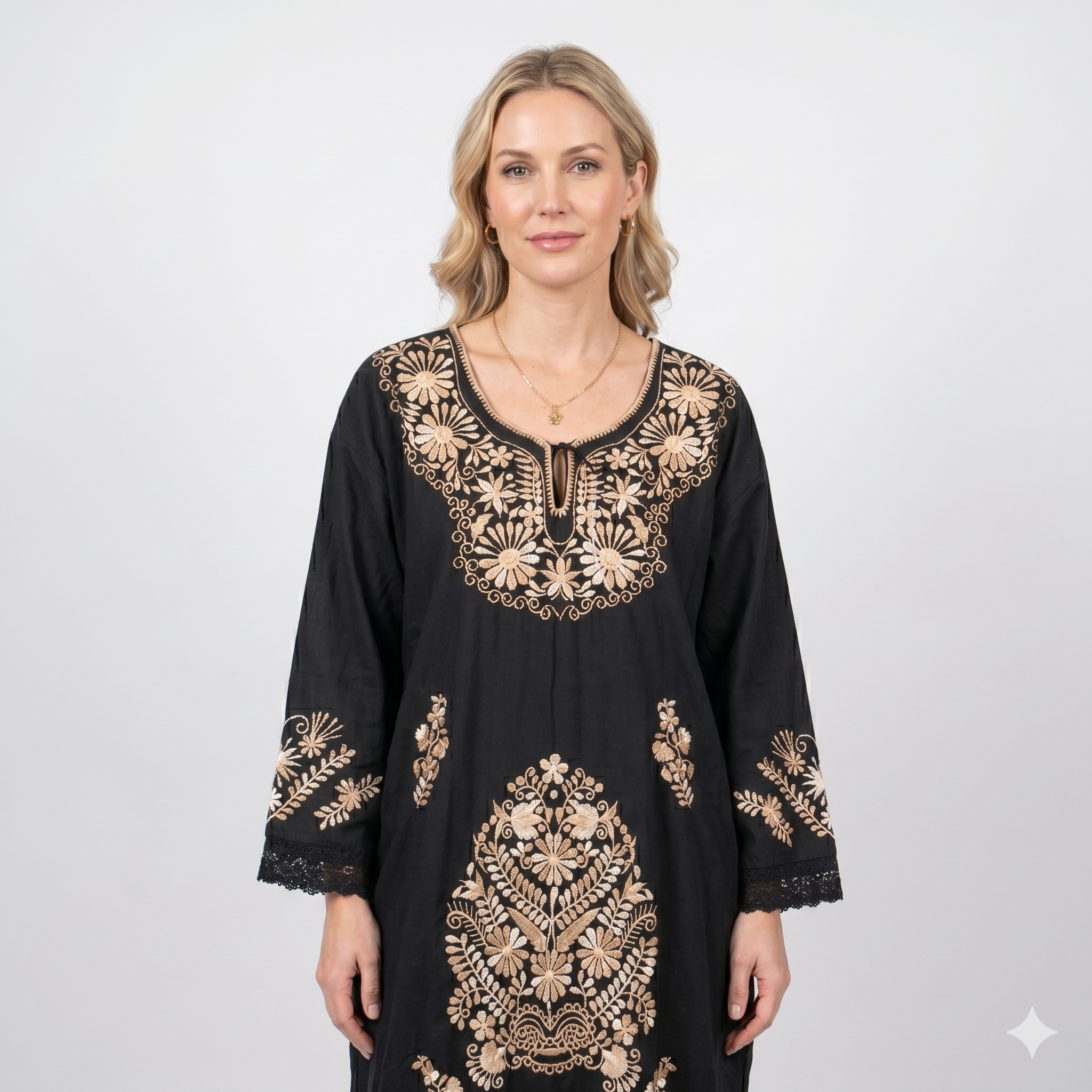 Mannequin blonde portant la robe longue noire à motifs floraux dorés, vue de face, mettant en avant le tombé impeccable du tissu et les finitions haut de gamme.