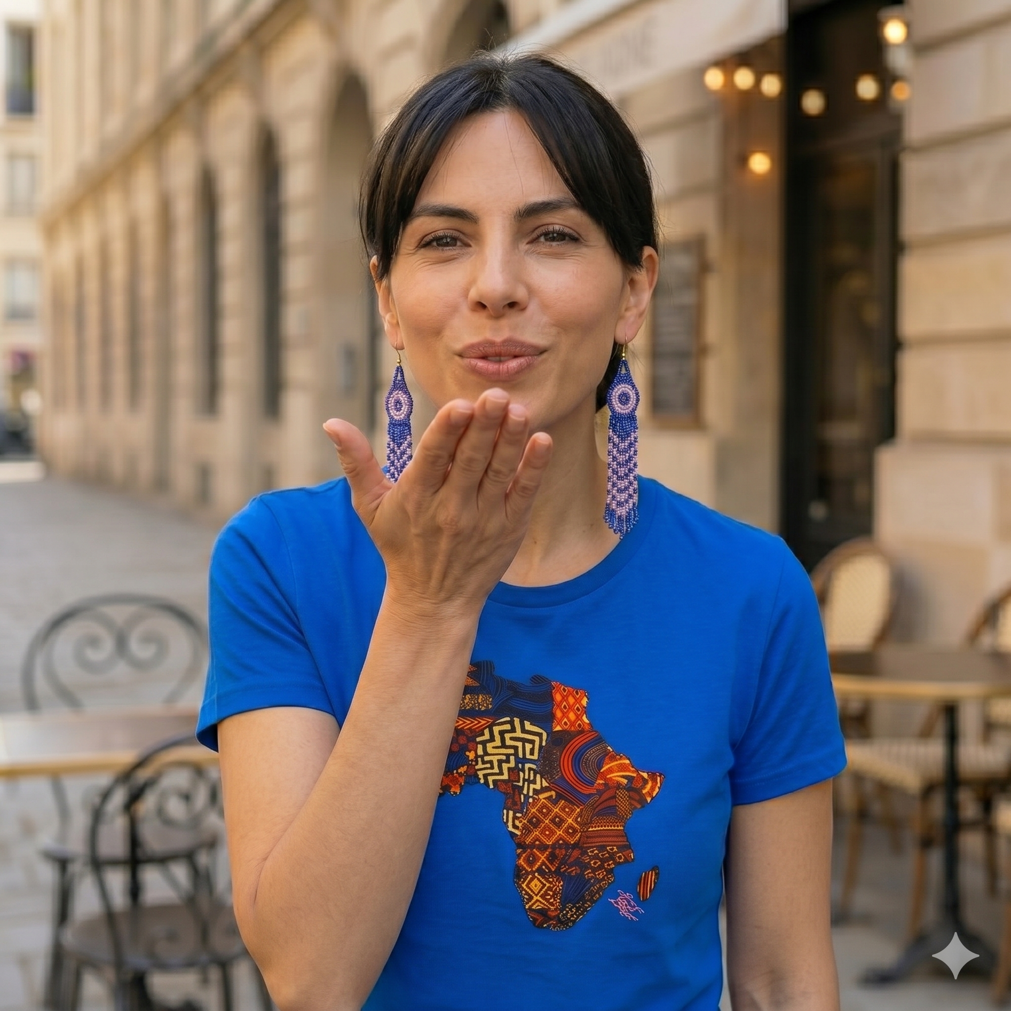 eune femme souriante envoyant un baiser, portant le t-shirt bleu motif Afrique des Ateliers BECCAR.